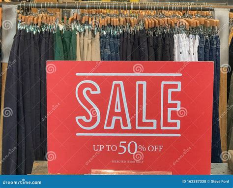 A Red Sale Sign Inside A Clothing Store Advertising 50 Off Stock Photo