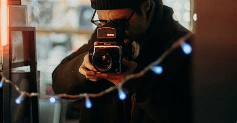 Selective Focus Photography Of Man Using Black Camera · Free Stock Photo