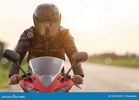 Handsome Motorcyclist Wear Leather Jacket And Holding Helmet On The