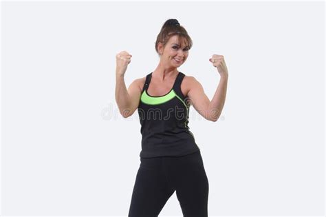 Attractive Middle Aged Woman In Sports Gear Smiling And Clenching Fists