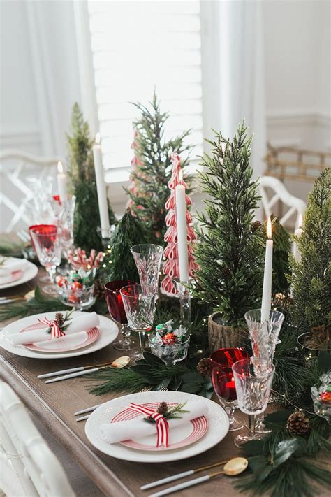 a christmas table setting with candles and plates