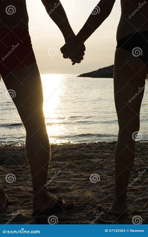 Couple On A Beach Holding Hands At Sunset Stock Image Image Of Relationship Silhouettes 57152563