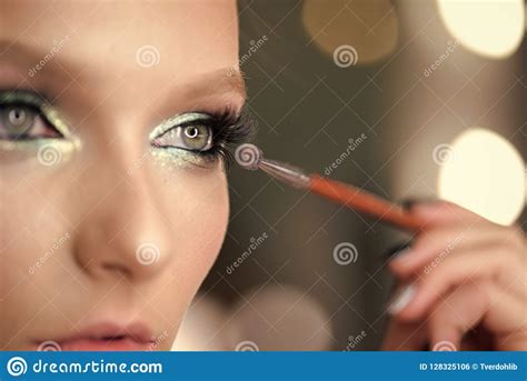 Woman Applying Black Mascara On Eyelashes With Makeup