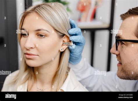 Otolaryngologist Doctor Checking Young Womans Ear Using Otoscope Or