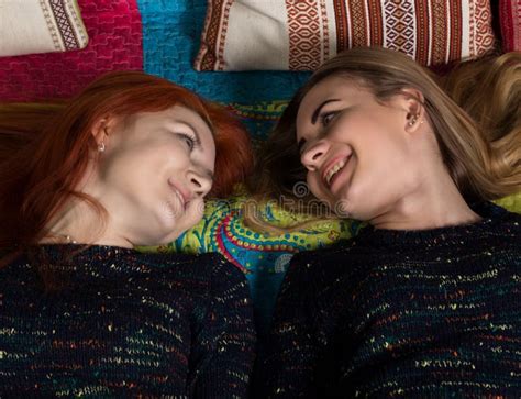 twee mooie lesbiennesmeisjes die en in een comfortabele atmosfeer kussen koesteren stock foto