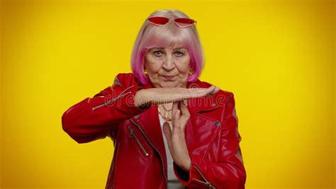 senior old stylish rocker granny woman with pink hair showing time out gesture limit or stop