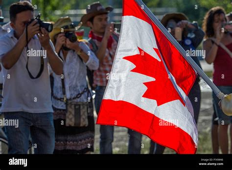 People Taking Photos Of The Canadian Flag At The Calgary Stampede