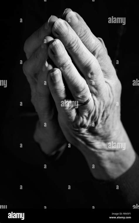 Black And White Image Of Senior Womans Hands Joined In Prayer Stock