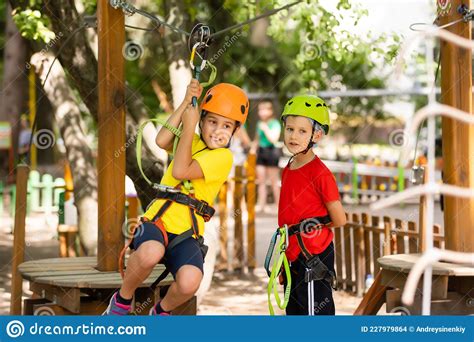 Child In Forest Adventure Park Kids Climb On High Rope Trail Agility