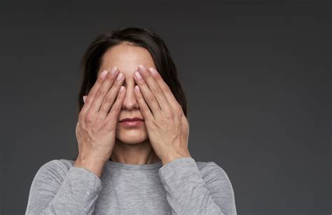 premium photo woman covering her face with her hands copyspace provided on gray background