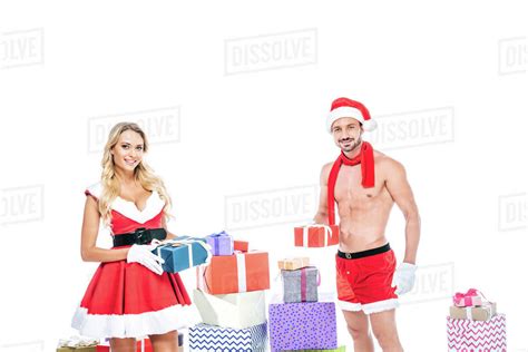 Beautiful Babe Woman In Santa Dress And Muscular Shirtless Man In Christmas Hat Giving Presents