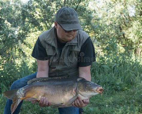 Carp Fishing Fisherman With Fish Trophy In Hands At Lake Stock Image