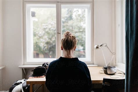 Woman Sitting At Desk In Front Of Window By Stocksy Contributor
