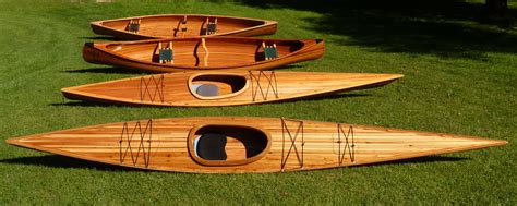 Three Wooden Canoes Sitting On Top Of Green Grass