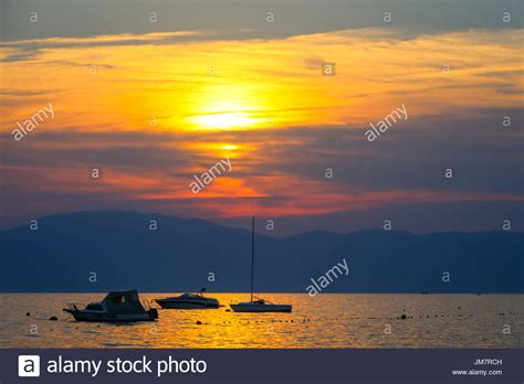 Sunset At Adriatic Sea With Boats Anchored And Island Cres In The