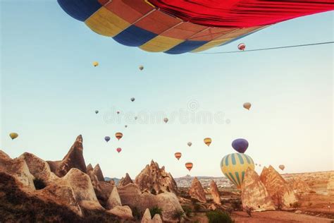 Hot Air Balloon Flying Over Rock Landscape At Turkey Cappadocia Stock