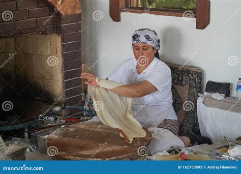 a woman cook in the traditional manual way bakes a turkish gozleme cake in an old oven