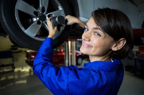 Free Photo Portrait Of Female Mechanic Fixing A Car Wheel With