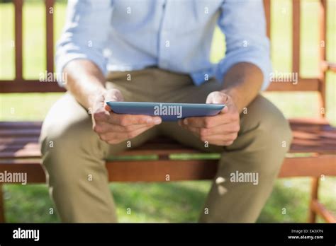 Man Sitting On Park Bench Using Tablet Stock Photo Alamy