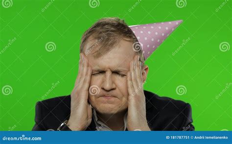 Drunk Disheveled Young Businessman With Hangover In Festive Cap Having Headache Stock Image