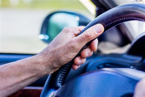 Man S Hand On Steering Wheel Of A Car Driving On The Road Stock Photo