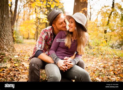 Romantic Young Couple Sitting In Autumn Forest Stock Photo Alamy