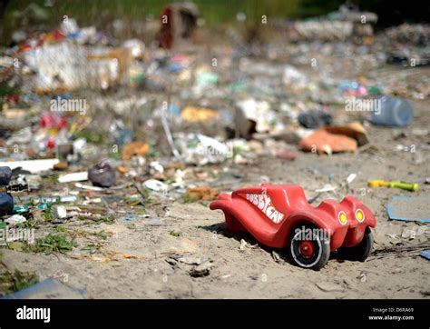 An Abandoned Broken Toy Car Stands Between Piles Of Rubbish In The