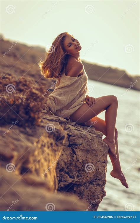 Ragazza Che Si Siede Sulla Spiaggia Dopo Il Tramonto Nei Precedenti Del