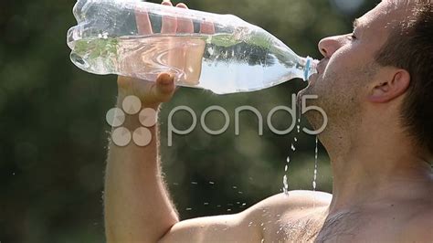 Man Drinking Water From A Plastic Bottle In Nature Slow Motion Stock
