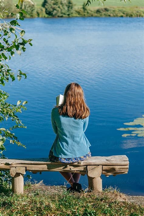 Teen Girl Reading Book Outside By Pond By Stocksy Contributor