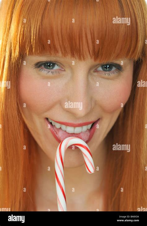 Woman Licking Candy Cane Stock Photo Alamy