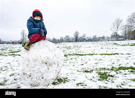 Ein Junge Sitzt Auf Einem Riesigen Felsbrocken Aus Schnee Im Prospect Park In Reading Berkshire