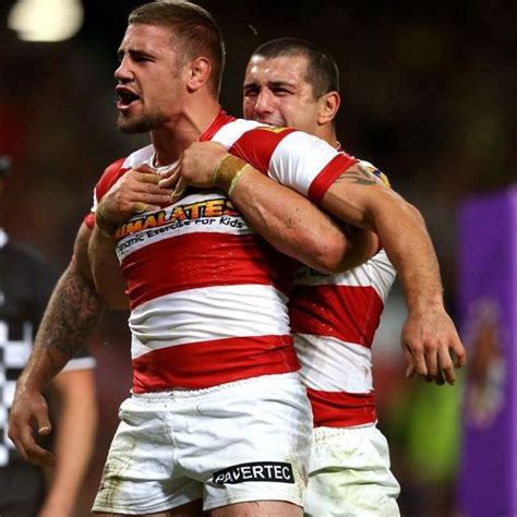 Two Rugby Players Are Hugging Each Other On The Field