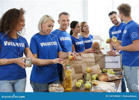 Team Of Volunteers Collecting Food Donations At Table Royalty Free