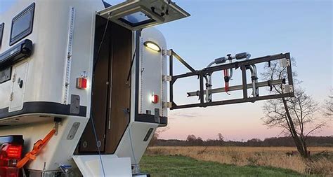 An Rv Parked On The Side Of A Road With Its Door Open And Lights On