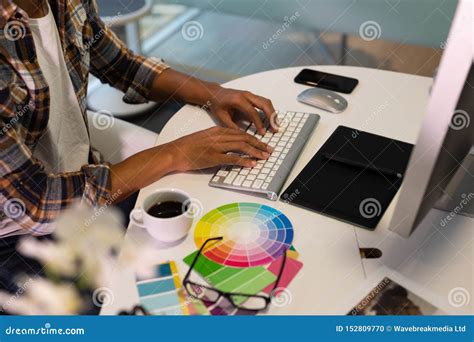 Male Graphic Designer Working On Computer At Desk In Office Stock Photo