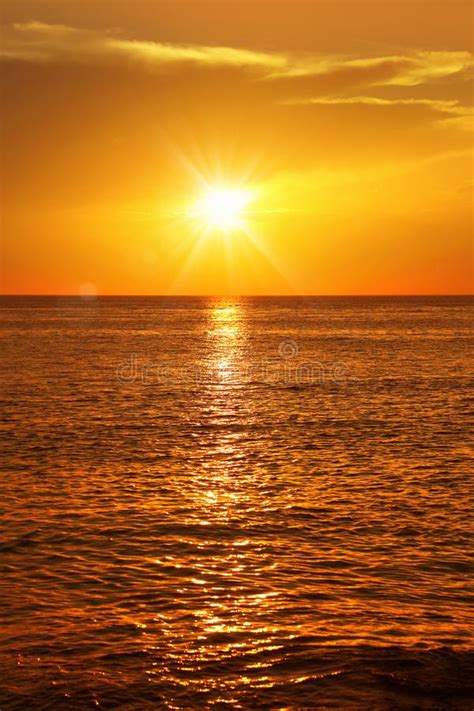 Seascape With Shiny Sea Over Cloudy Sky And Sun During Sunset In