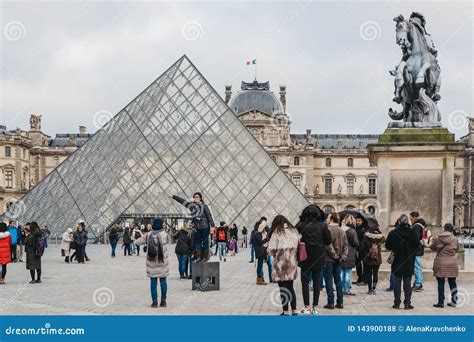 Tourists Taking Pictures In Front On The Louvre Museum In Paris France