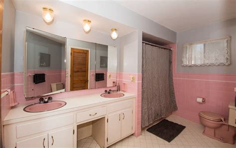 A Bathroom With Pink And White Walls And Two Sinks
