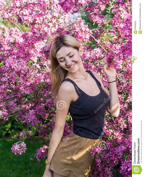 Beautiful Smiling Young Woman Near The Blossoming Spring Tree Portrait