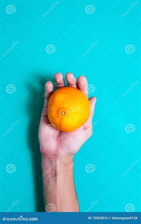 Fresh Orange Fruits And Juice On Hand In Blue Background Table Stock