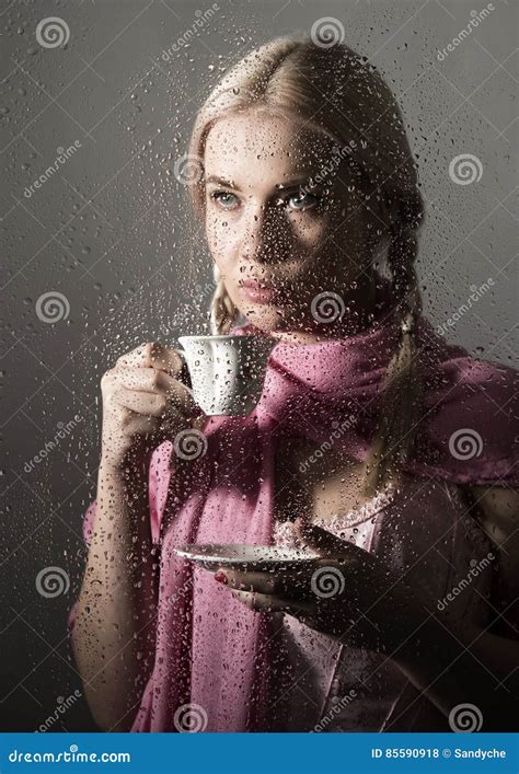 Young Woman Dressed In Sweater Drinking Coffee Or Tea Posing Behind