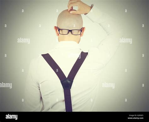 Back Of A Bald Headed Man In A White Shirt With Glasses On Nape