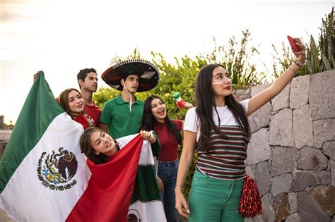 teenager latin friends taking selfies celebrating the mexican soccer team win outdoors stock