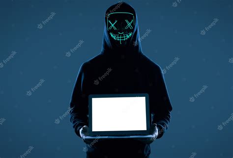 Premium Photo Anonymous Man In A Black Hoodie And Neon Mask Hacking