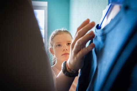 joven adolescente elige un traje adecuado en el armario en el dormitorio en casa ropa colgada