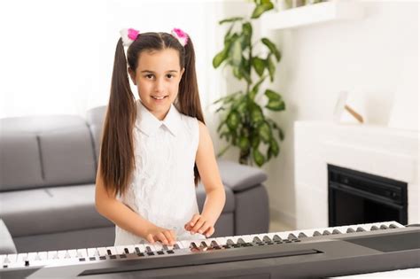 Premium Photo Beautiful Little Kid Girl Playing Piano In Living Room