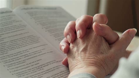 An Old Woman Prays With Her Hands On The Bible Close Up Stock Video