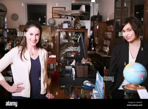 Two Women Standing On Opposites Sides Of A Counter In An Antiques Shop