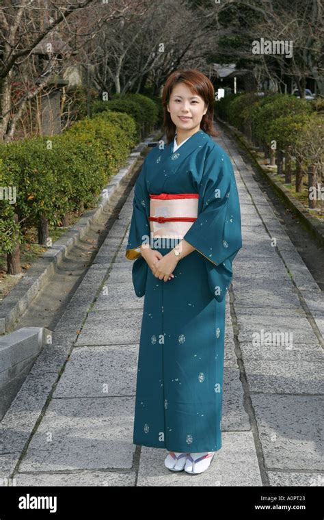 full length beautiful japanese woman wearing traditional kimono poses in kyoto backstreet kansai